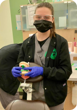 Dental assisting student holding smile model