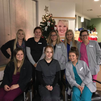 Dental assisting students in front of Christmas tree